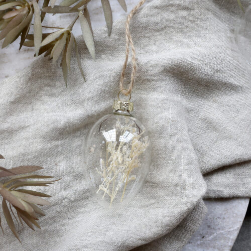 Osterei aus Glas mit getrockneten Blumen